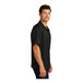 A man wearing a black Port Authority short sleeve camp shirt.
