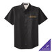 A black Port Authority short sleeve dress shirt with light stone embroidery on the counter.
