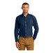 A man wearing an ink blue Port & Company short sleeve denim button-down shirt.