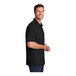 A man wearing a black Port Authority short sleeve moisture wicking shirt.