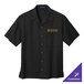 A black Port Authority camp shirt with gold embroidery on the pocket.