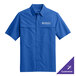 A blue Port Authority short sleeved shirt with a logo on the chest.