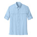 A Port Authority light blue long sleeve shirt for men with rolled up sleeves and a button.