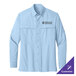 A Port Authority light blue long sleeve shirt with a logo on the chest.