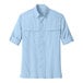 A Port Authority light blue long sleeve shirt for men with rolled up sleeves and a button.