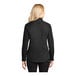 A woman wearing a Port Authority black and light stone long sleeve button down dress shirt.