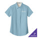 A light blue short sleeve Port Authority dress shirt for women with a light stone logo on the front.