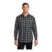 A man wearing a Port Authority black and grey buffalo check flannel shirt.