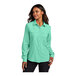 A woman wearing a bright seafoam Port Authority short sleeve shirt.