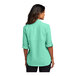 A woman wearing a bright seafoam short sleeve Port Authority shirt.