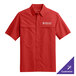 A small rich red Port Authority short sleeve shirt with a logo on the chest.