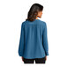 A woman wearing a Port Authority Aegean blue short sleeve blouse.