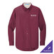A Port Authority long sleeved maroon dress shirt on a counter.