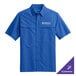 A small blue Port Authority short sleeve shirt with a logo on the chest.