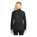 A woman wearing a black and light stone Port Authority long sleeve button down shirt.