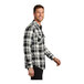 A man wearing a Port Authority snow white and black plaid flannel shirt.