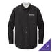 A black Port Authority long sleeve dress shirt on a counter with the logo on the chest.