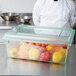 A Carlisle StorPlus green lid on a food storage container of peppers.