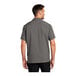A man wearing a grey Port Authority short sleeved performance staff shirt.
