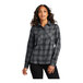 A woman wearing a gray and black Port Authority long sleeve plaid flannel shirt.