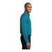 A person wearing a teal green Port Authority long sleeve dress shirt.