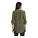 A woman wearing a deep olive short sleeve Port Authority blouse.