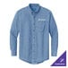 A Port & Company faded blue denim button-down shirt with long sleeves on a table.