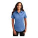 A woman wearing a Port Authority ultramarine blue short sleeve dress shirt.