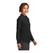 A woman in a Brooks Brothers black satin long sleeve shirt with the buttons undone.