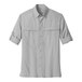 A Port Authority men's grey long sleeve shirt with rolled up sleeves.