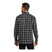 A man wearing a gray and black Port Authority buffalo check flannel shirt.