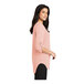 A woman wearing a Port Authority rose quartz short sleeve blouse.