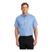 A man wearing a Port Authority light blue short sleeve dress shirt.