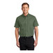 A man wearing a Port Authority short sleeve green dress shirt.