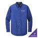 A medium blue Port Authority long sleeve dress shirt on a counter with a logo on the chest.