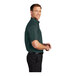 A man wearing a dark green Port Authority short sleeve dress shirt.