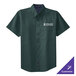 A close-up of a dark green Port Authority short sleeve dress shirt with a logo on it.