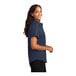 A woman wearing a navy and light stone Port Authority short sleeve dress shirt.