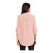 A woman wearing a rose quartz Port Authority short sleeve blouse.