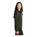 A woman wearing a Mercer+Mettle long sleeve green camp blouse with the sleeves rolled up.