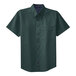 A dark green short sleeved Port Authority dress shirt with a buttoned collar.