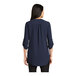 A woman wearing a navy Port Authority short sleeve blouse.