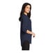 A woman wearing a Port Authority navy short sleeve tunic blouse.