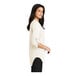 A woman wearing a Port Authority ivory chiffon blouse with short sleeves.