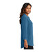 A woman wearing an Aegean blue short sleeve blouse.