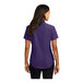 A woman wearing a purple and light stone Port Authority short sleeve button down dress shirt.