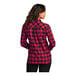 A woman wearing a red and black plaid Port Authority flannel shirt.