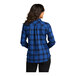 A woman in a royal blue and black plaid Port Authority flannel shirt.