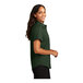 A woman wearing a dark green Port Authority short sleeve dress shirt.