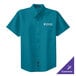 A teal Port Authority short sleeve button up dress shirt with white text on the pocket.